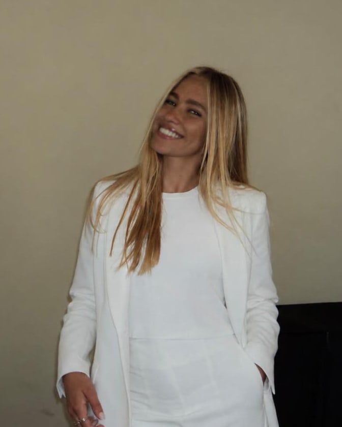 Marisol, sonriendo, con un traje blanco